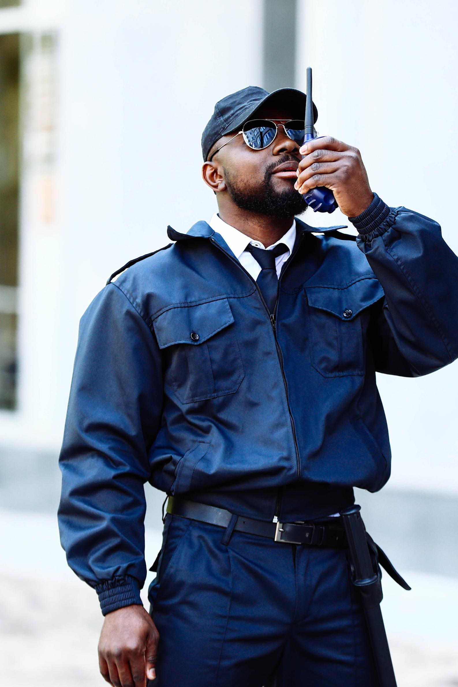 Man in security uniform standing in front of a building.